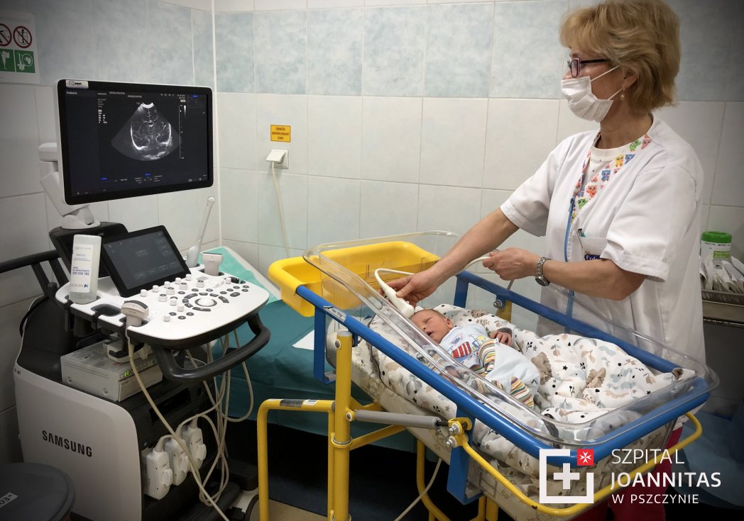 Lekarka badająca główkę noworodka specjalistycznym sprzętem.