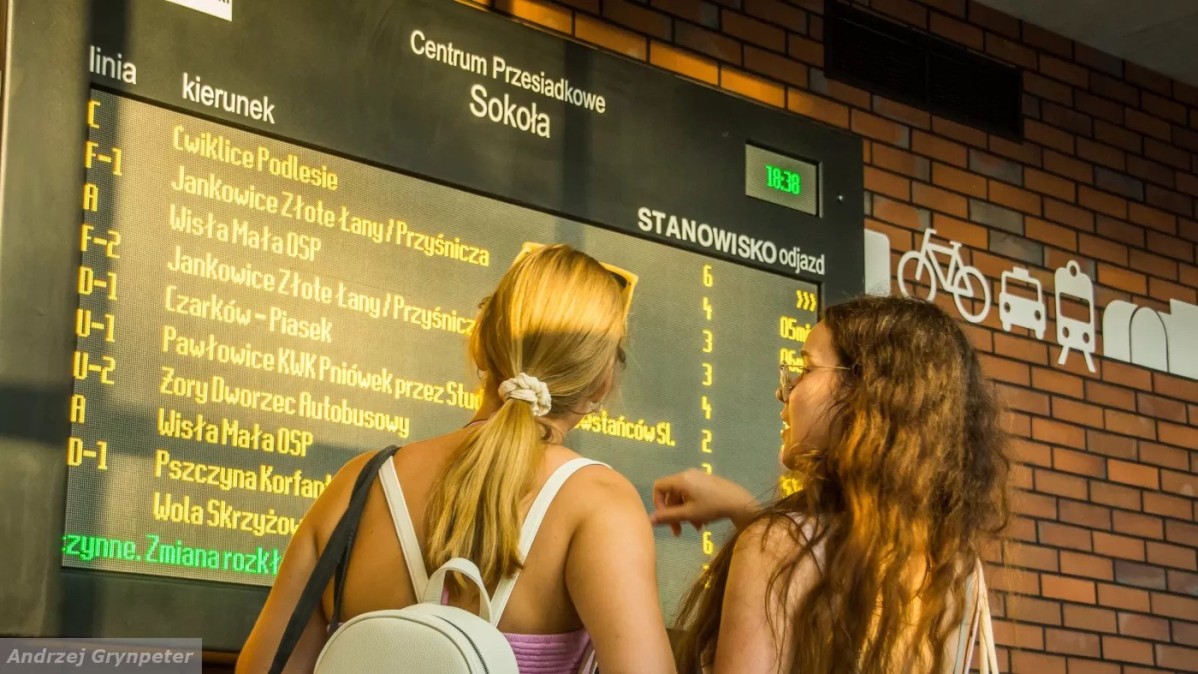 Dziewczyny oglądające rozkład jazdy w centrum przesiadkowym.