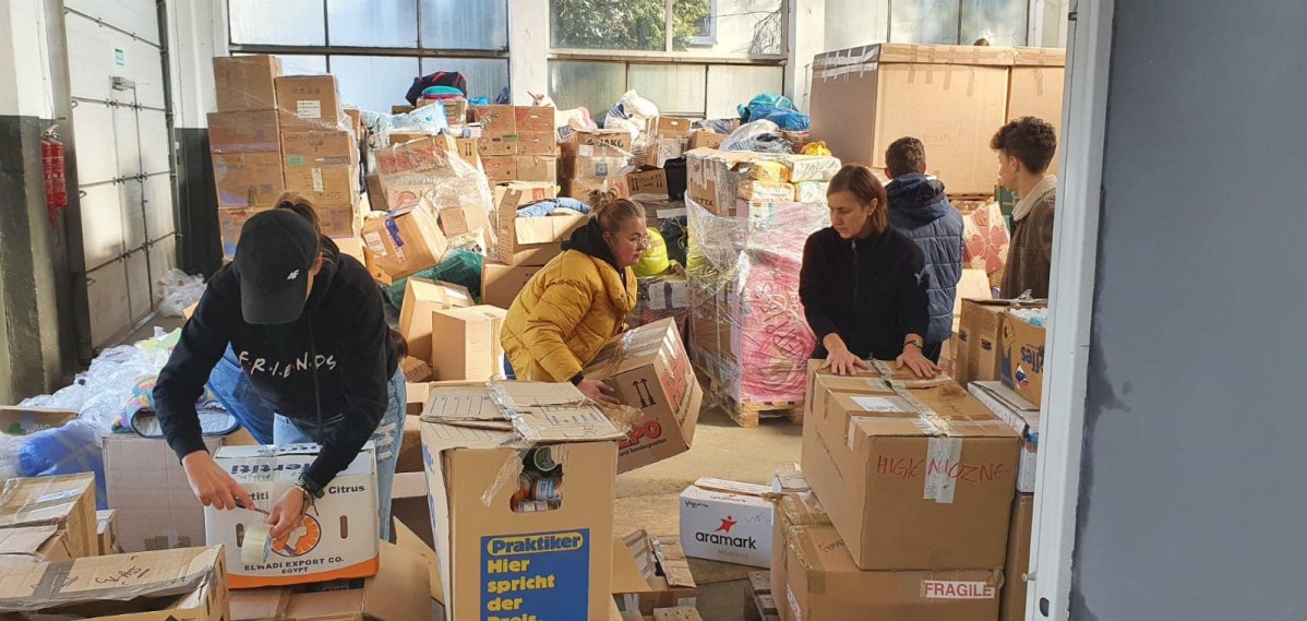 w dużej hali trwa układanie segregowanie darów przyniesionych dla uchodźców