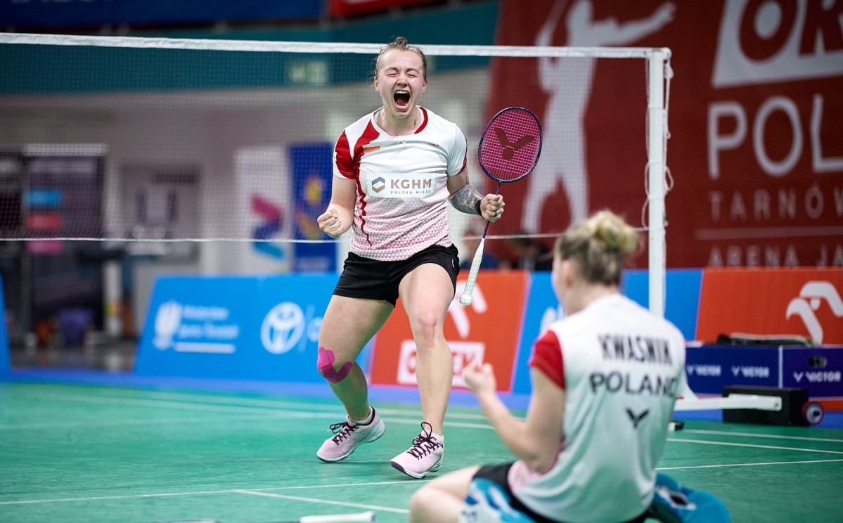 Badmintonistka z rakietą ucieszona na korcie.