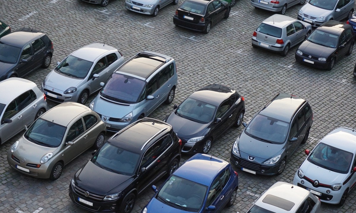 Samochody zaparkowane obok siebie na dużym parkingu.