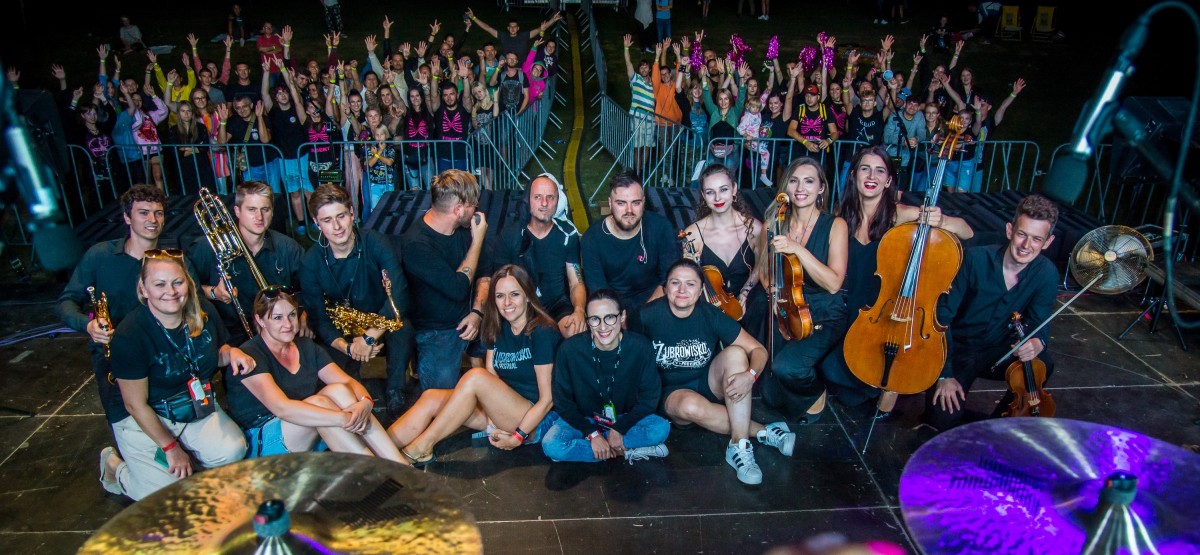 Zespół insekt oraz organizatorki siedzą na scenie, za nimi publiczność