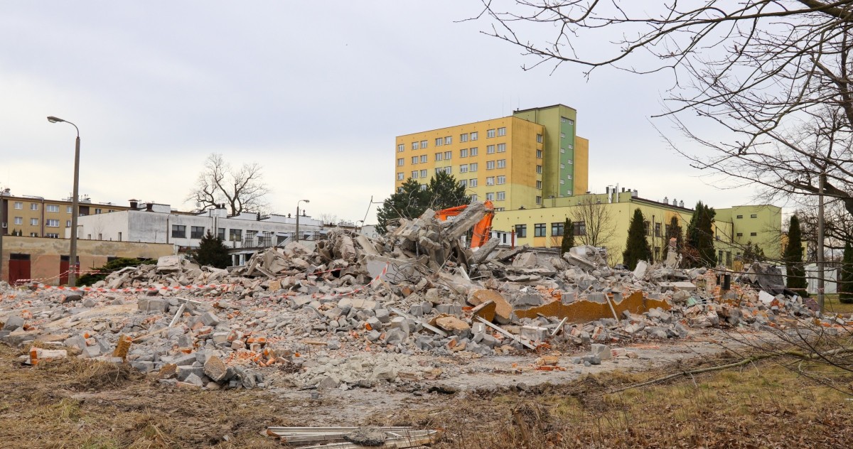 Góra gruzu po zburzonym budynku. W tle pszczyński szpital