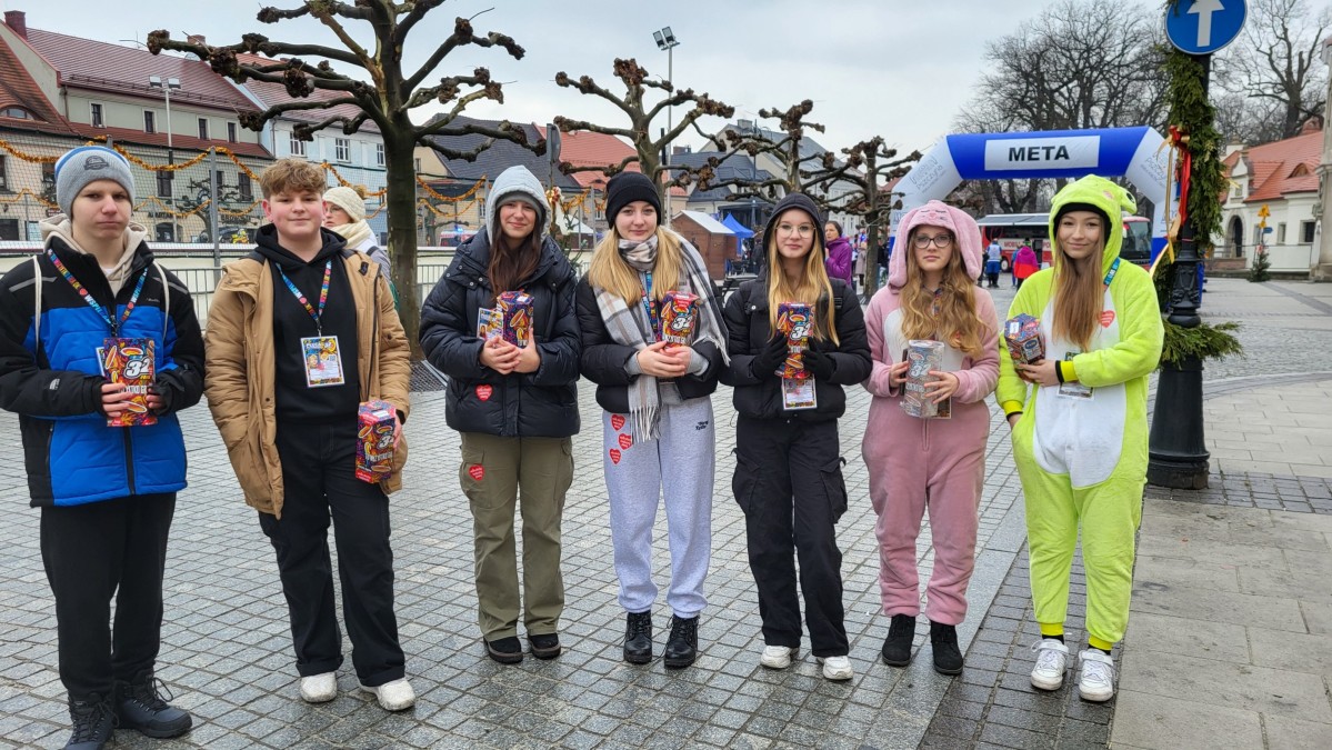 Wolontariusze wośp w przebraniach, stoją w puszkami na rynku w Pszczynie.