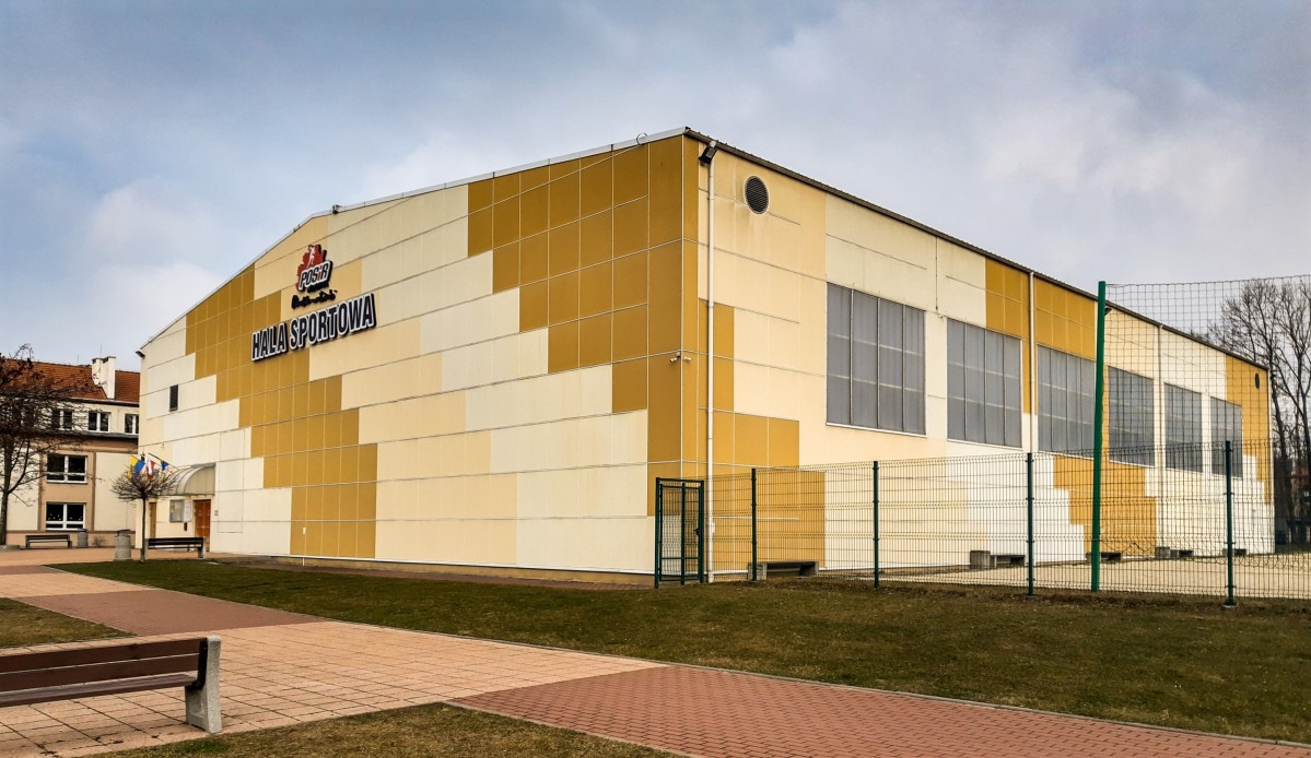Żółty budynek hali sportowej.