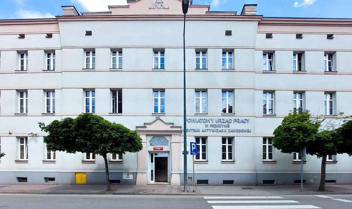 Budynek Powiatowego Urzędu Pracy w Pszczynie. Przed nim droga z przejściem dla pieszych.