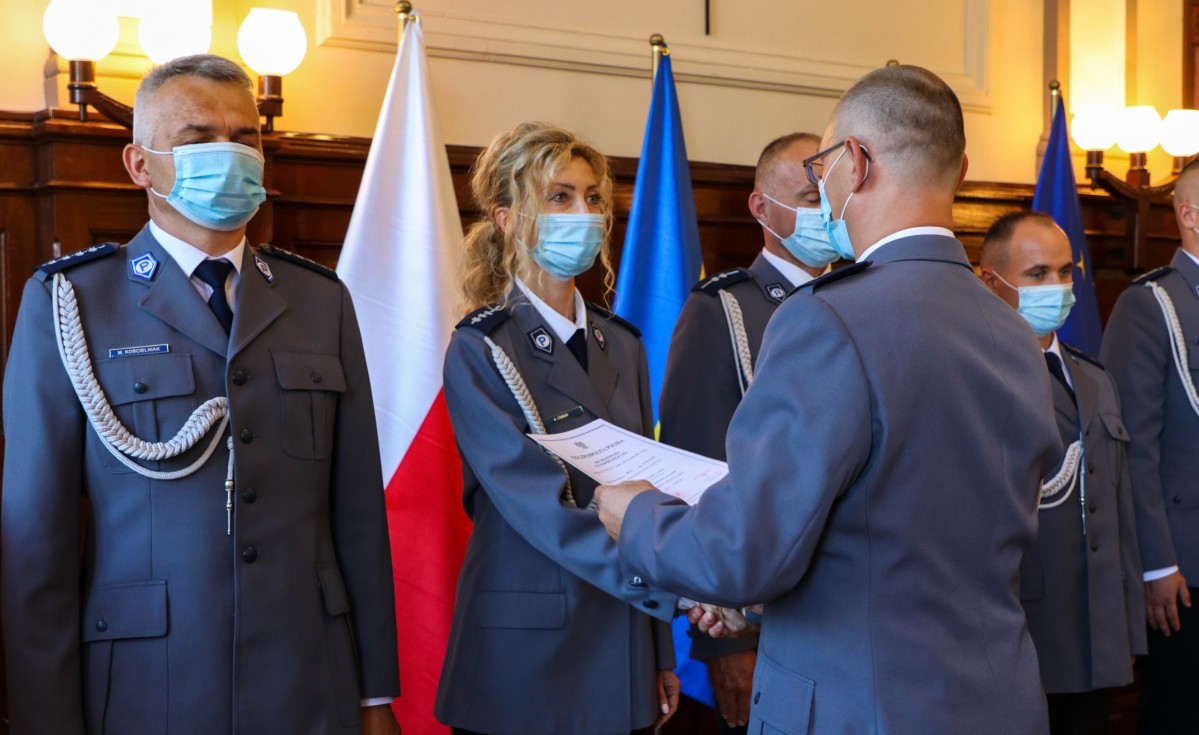 Komendant powiatowy policji w Pszczynie wręczający akty nominacyjne policjantom.