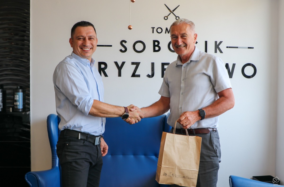 Grzegorz Nogły gratuluje Tomaszowi Sobocikowi w jego salonie fryzjerskim