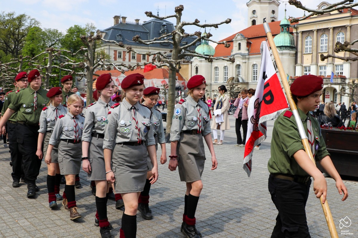 Poczty sztandarowe w przemarszu przez rynek.