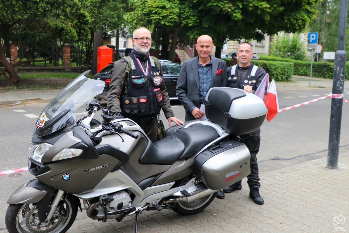 Dwóch motocyklistów oraz sekretarz powiatu stoją przy motocyklu