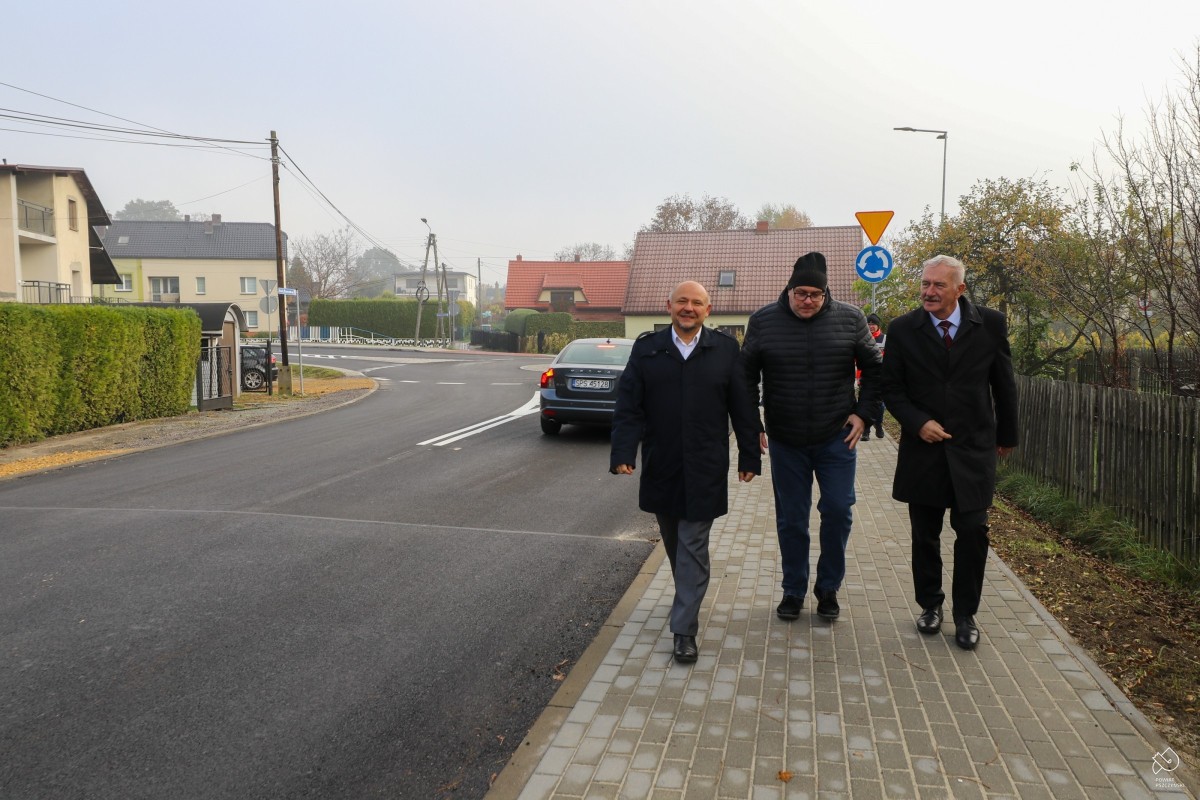 Starosta, członek zarządu i przewodniczący osiedla stara wieś idą wyremontowanym chodnikiem