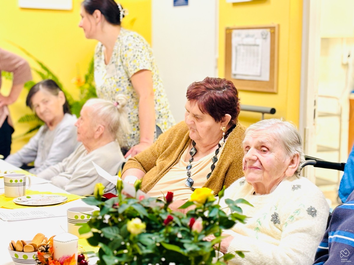 Seniorzy siedzą przy stole.