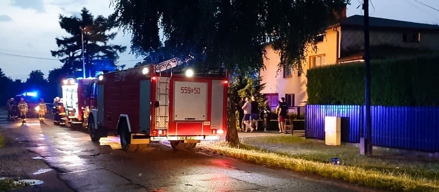Straże pożarne stojące przed budynkiem.