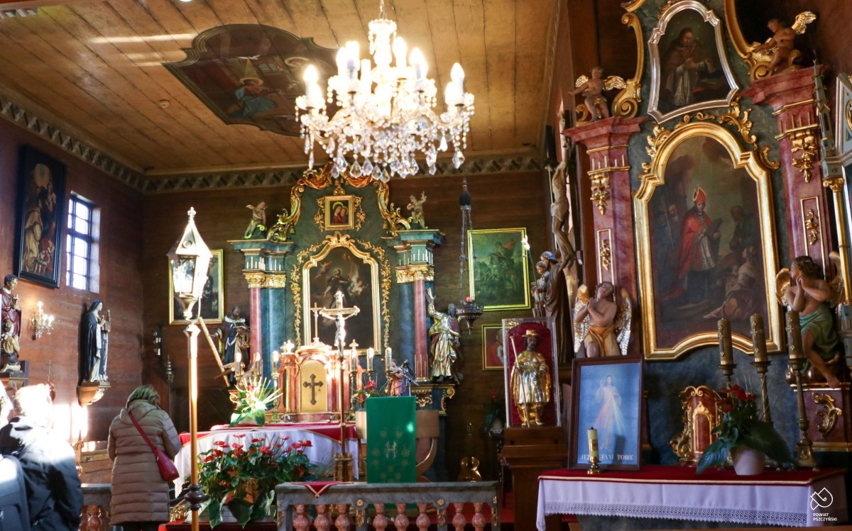 Wnetrze zabytkowego drewnianego kościoła w Wisle Małej, malowidła, ołtarz, lampa.