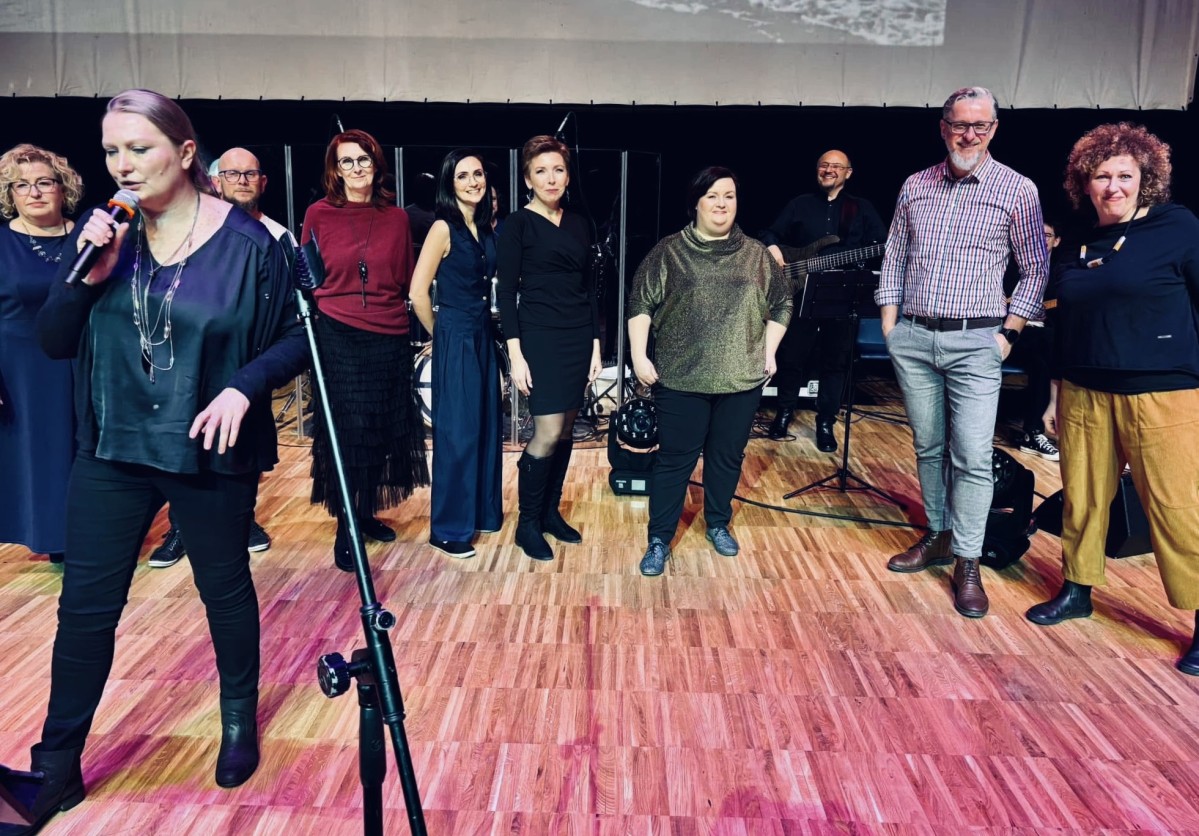 Grupa osób występuje na scenie.