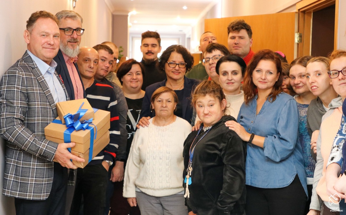 Podopieczni i pracownicy ŚDS w Grzawie ze starostą i wicestarostą we wspólnym zdjęciu na korytarzu.