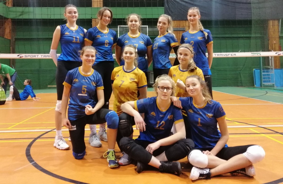 Zdjęcie grupowe serniorek UKS Centrum Pszczyna. Hala sportowa, w tle siatka.