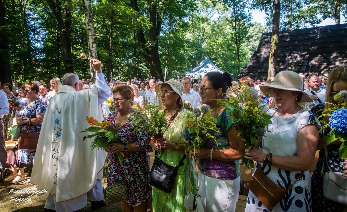 Ludzie w skansenie z bukietami kwiatów podczas święcenia bukietów.