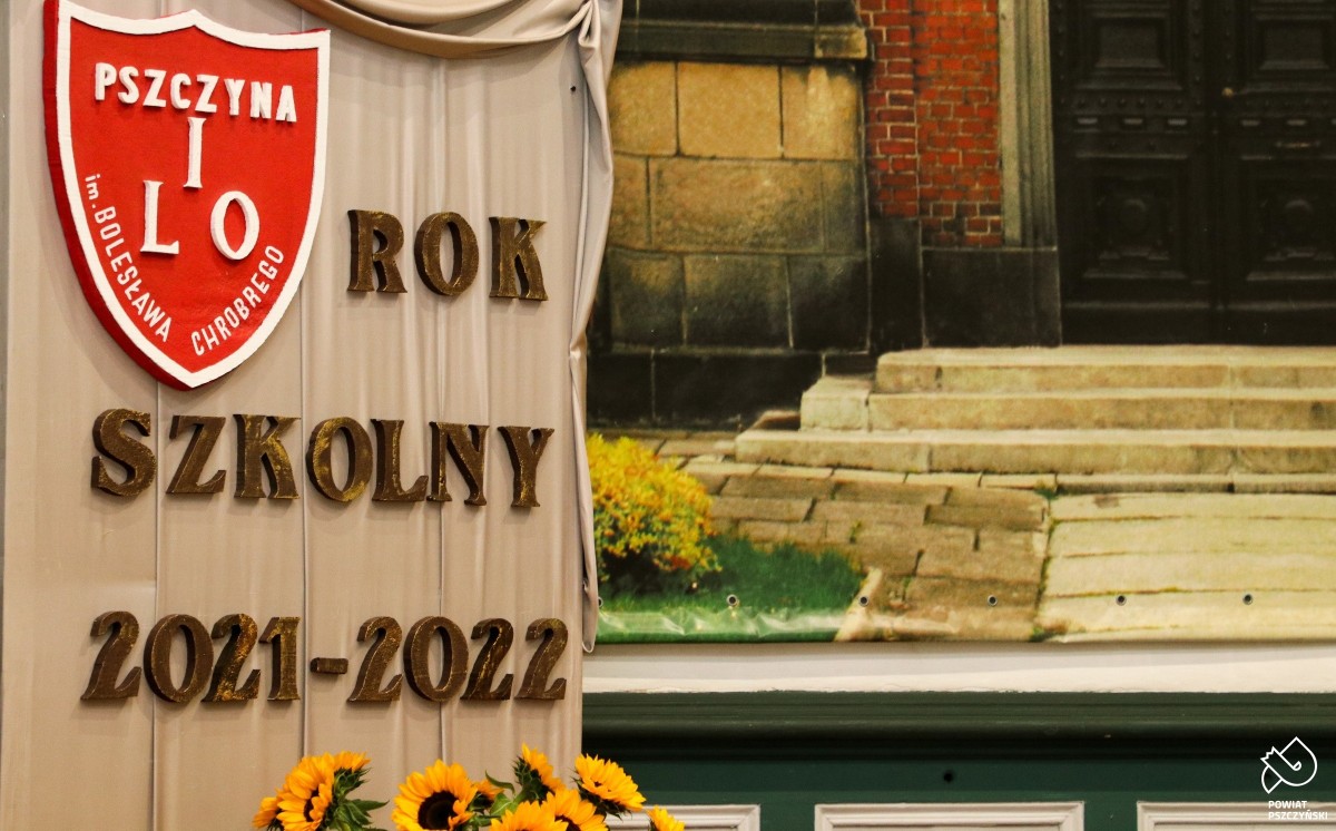 Dekoracja w pomieszczeniu szkolnej auli, z napisem Rok Szkolny 2021/22 oraz czerwona szkolna tarcza z napisem Pszczyna I LO