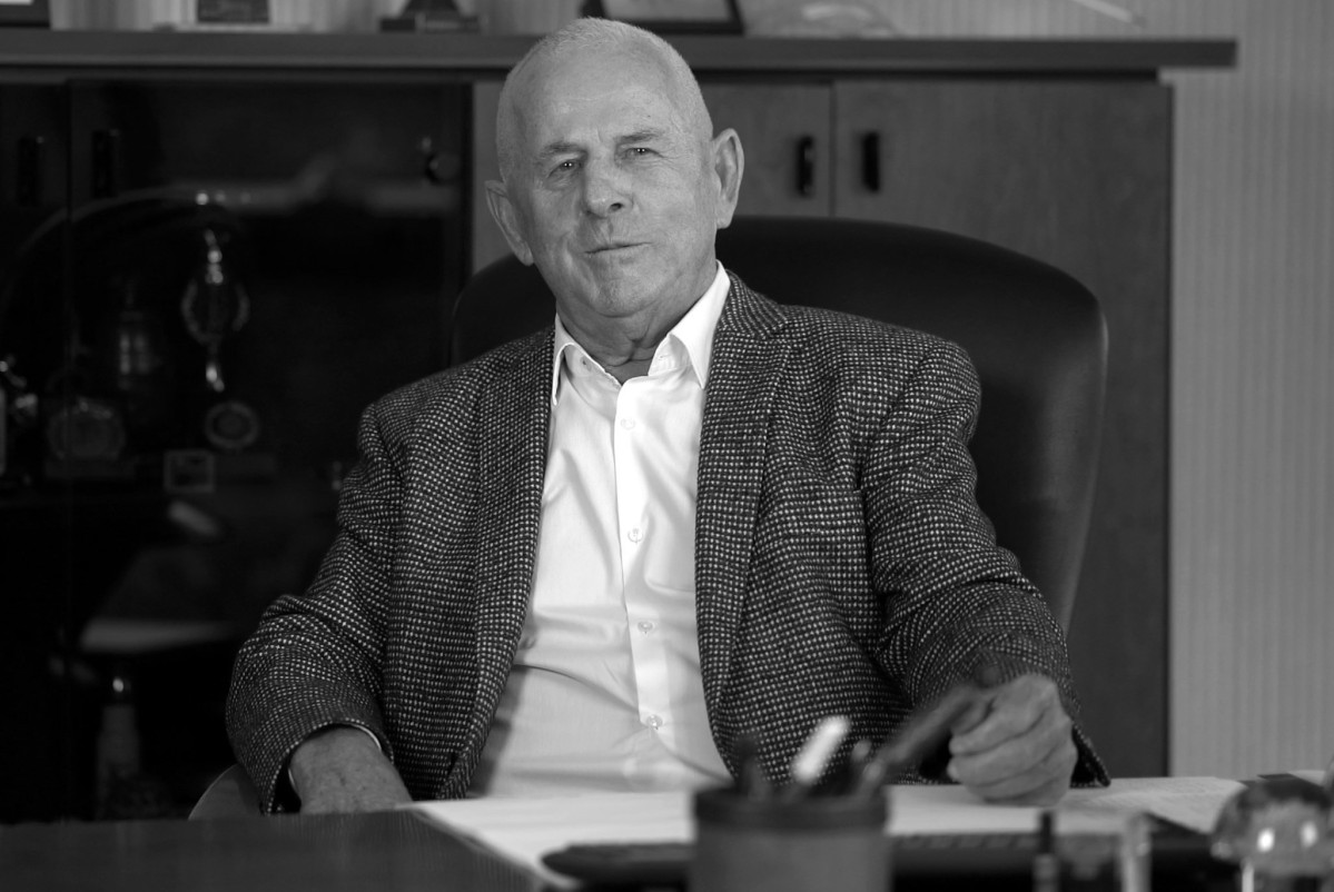 Mężczyzna siedzi za biurkiem. Zdjęcie czarno-białe.
