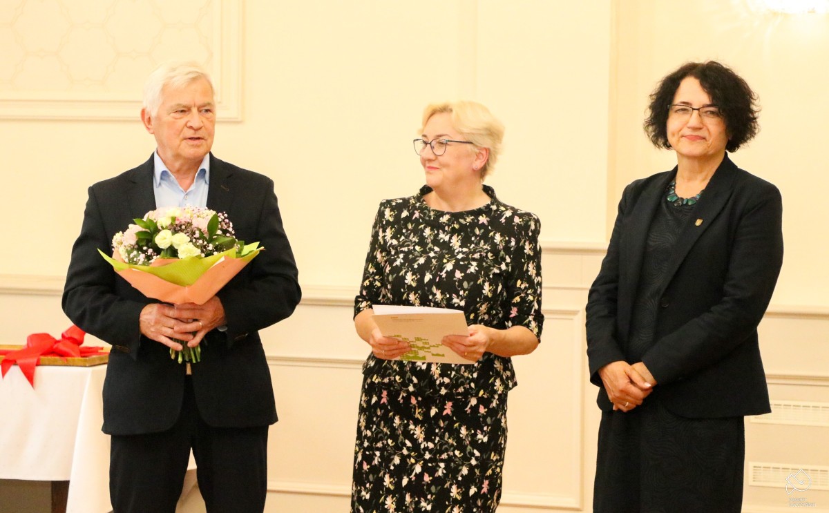 Wiceprzewodniczący Rady Powiatu trzyma kwiaty, obok dyrektorka biblioteki i wicestarosta.