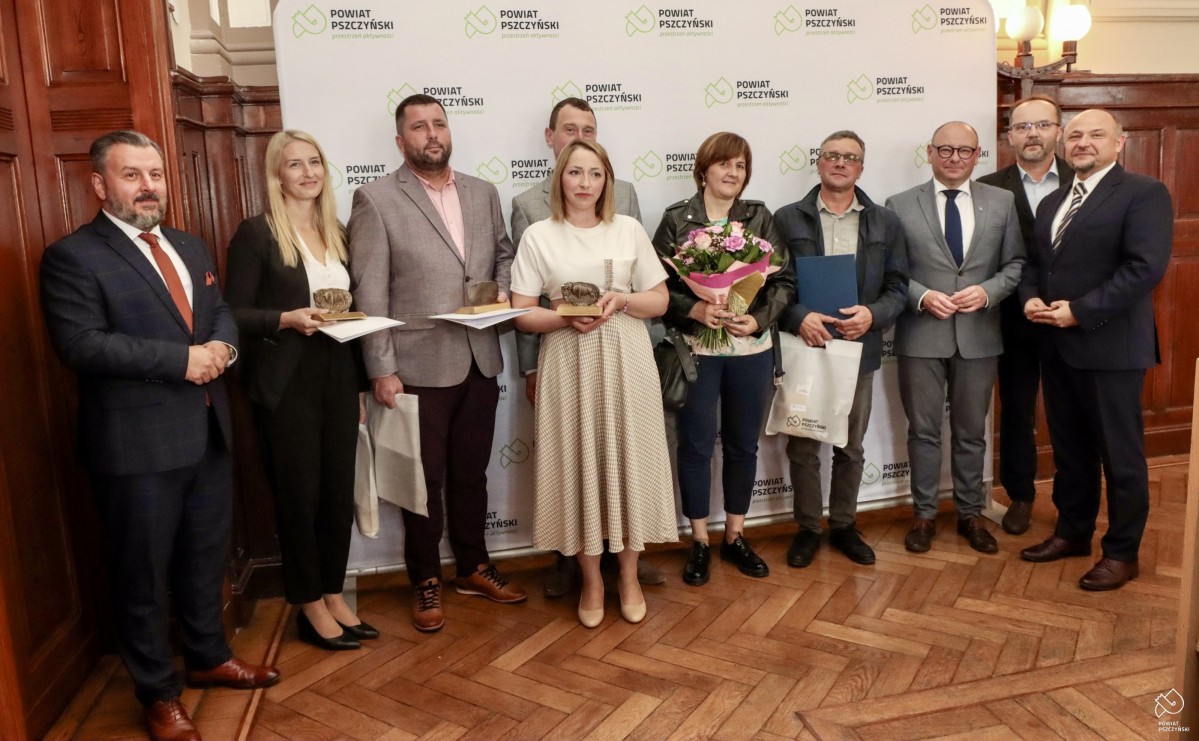 Wyróżnieni rolnicy z samorządowcami na tle ścianki Powiatu.