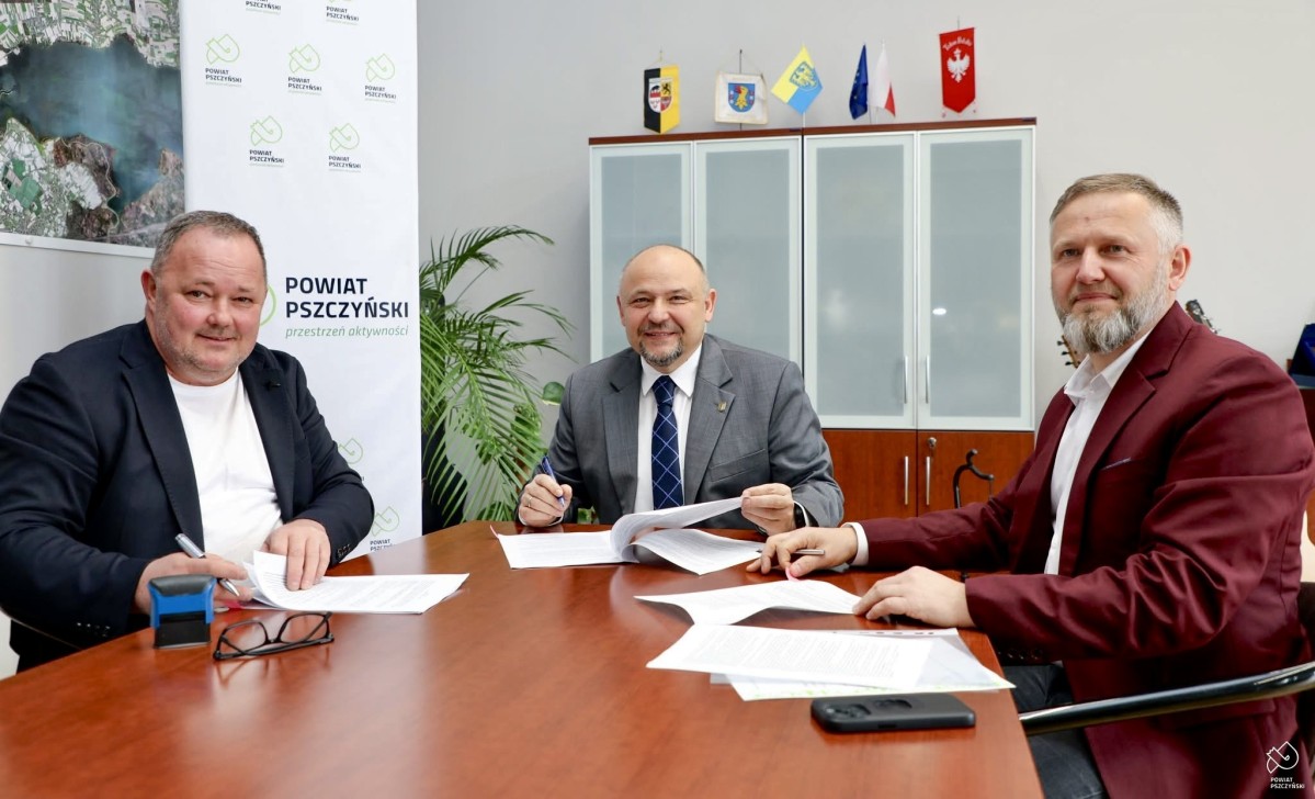 Starosta, dyrektor PZD w P-nie i właściciel firmy z umowa położonymi na stole.