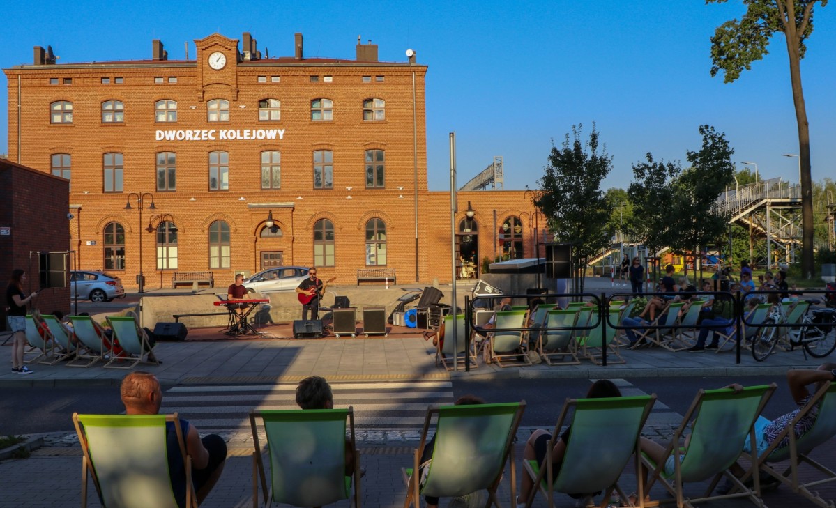 Koncert na placu przy centrum przesiadkowym. Dwaj muzycy grają na gitarze i klawiszach