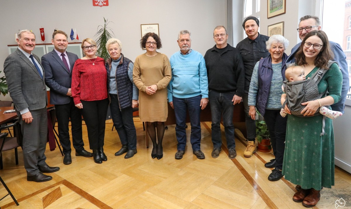 Grupa osób z Klein Ronnau oraz władze powiatu stoją obok siebie w gabinecie starosty.