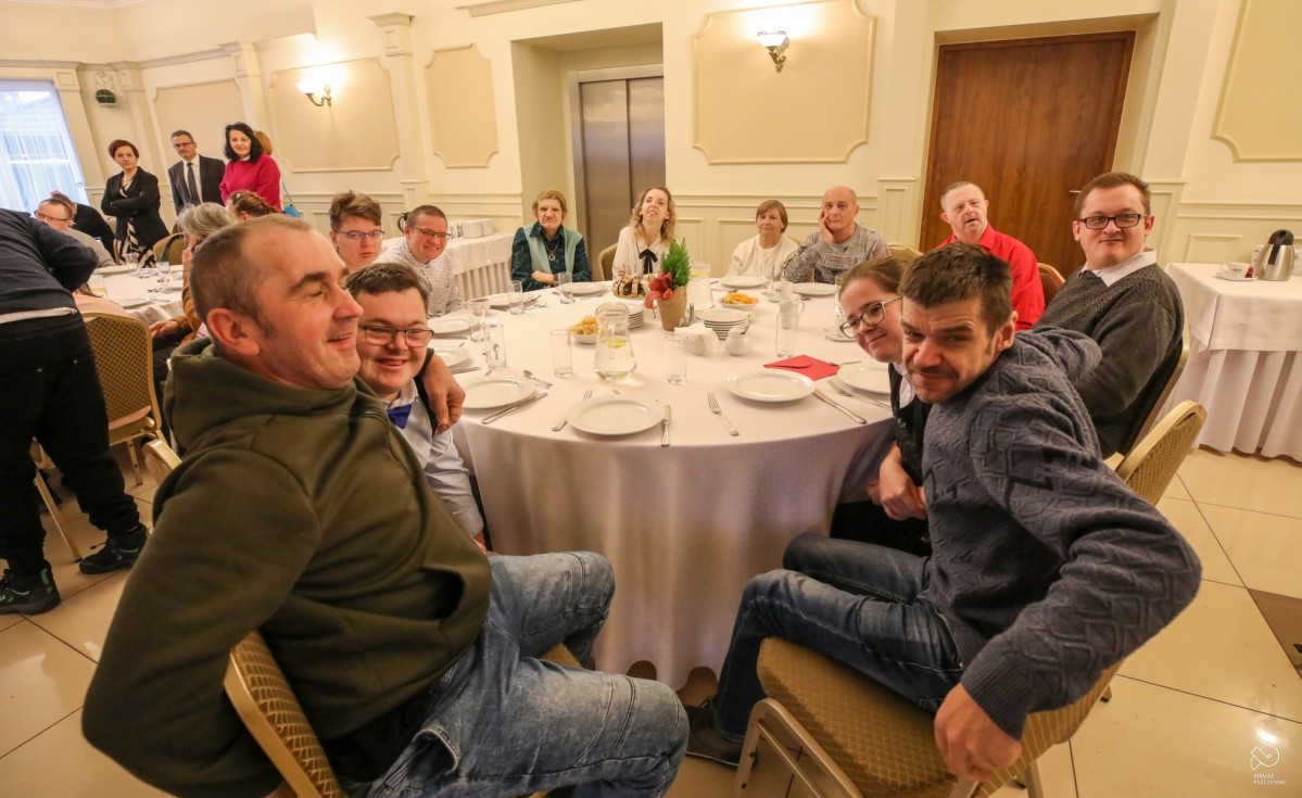 W restauracji za okrągłym stołem siedzą podopieczni ośrodka