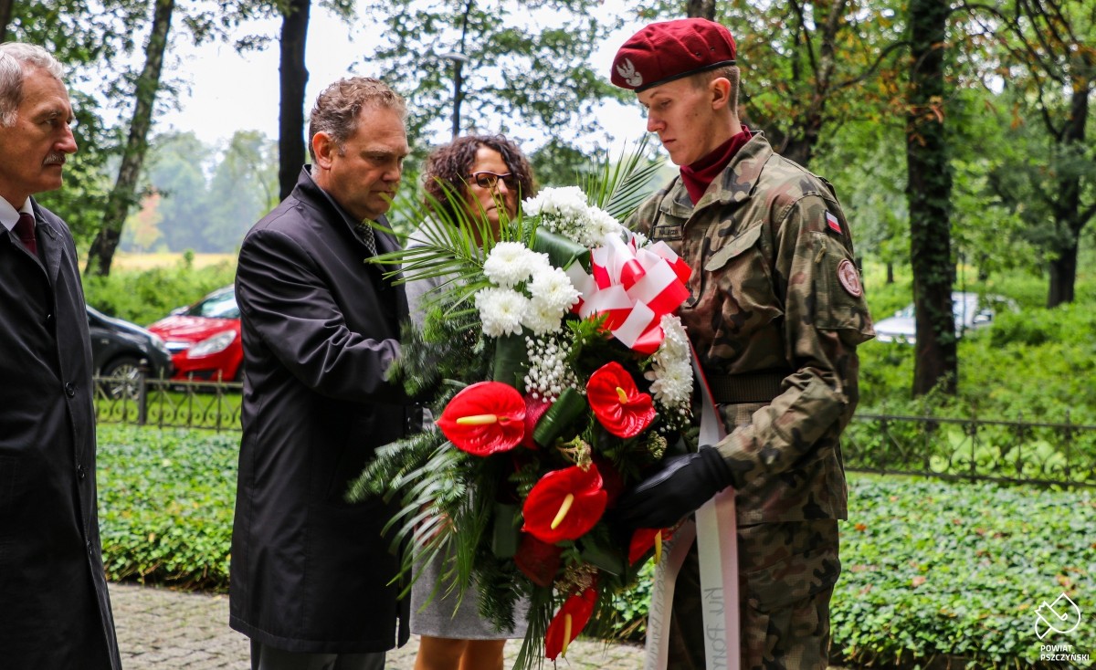 Wicestarosta Cieszewski przekazujący kwiaty żołnierzowi. Obok niego starosta Barbara Bandoła i Grzegorz Nogły.