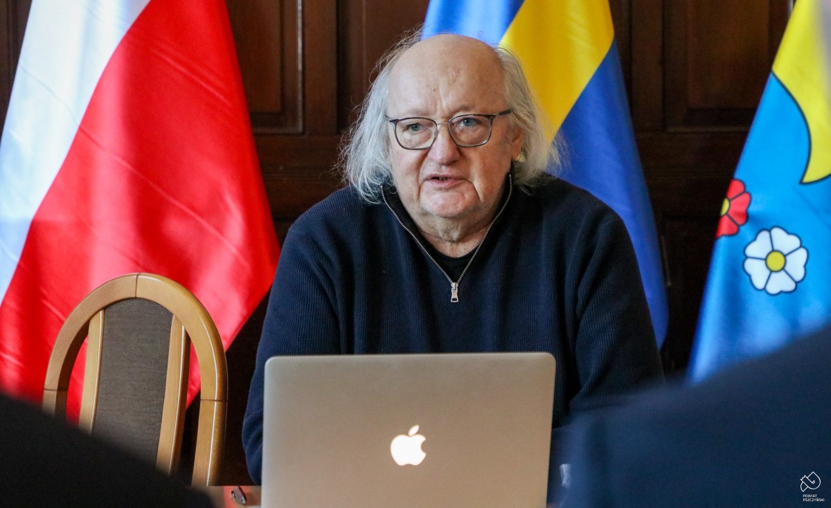 Mężczyzna siedzący za ekranem laptopa.