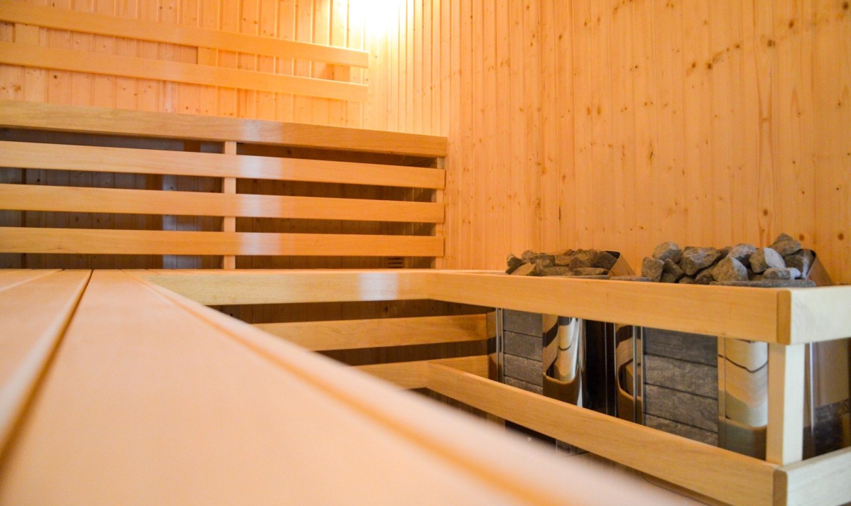 Sauna, drewniane siedziska, pojemnik na gorące kamienie.
