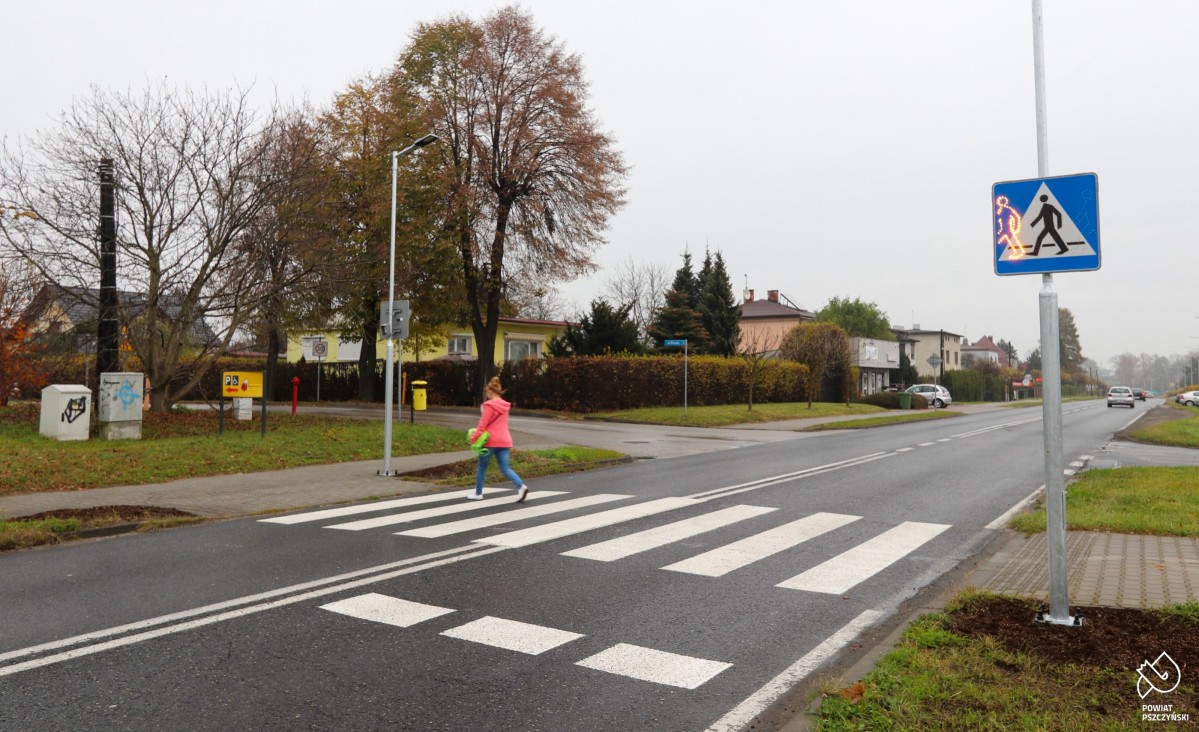 Przechodząca przez przejście dla pieszych kobieta.