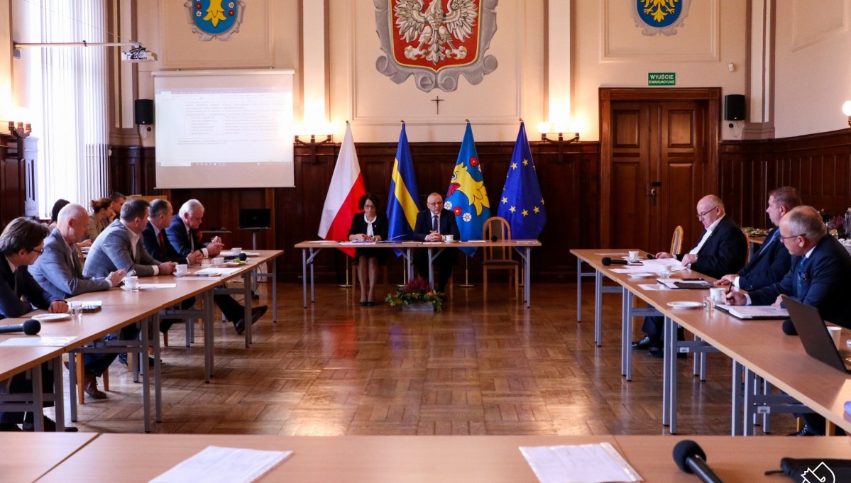 W sali sesyjnej starostwa trwa posiedzenie konwentu starostów wojeództwa. Uczestnicy siedza za stołami ułozonymi w prostokąt