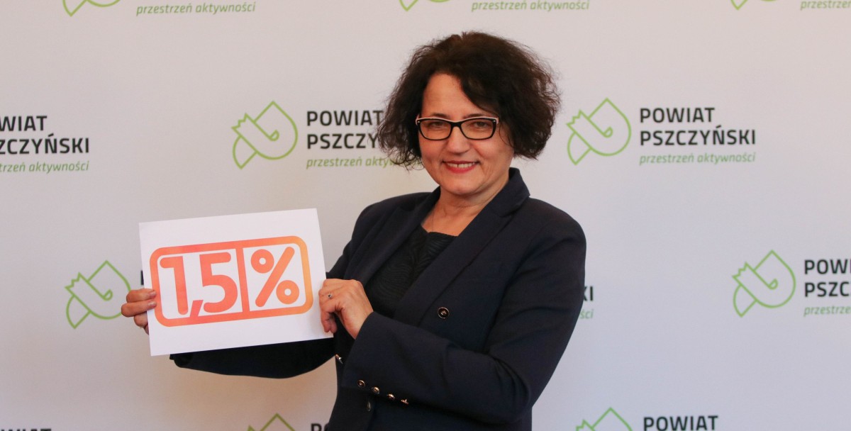 Starosta Barbara Bandoła trzma kartkę z pomarańczowym napisem 1,5%
