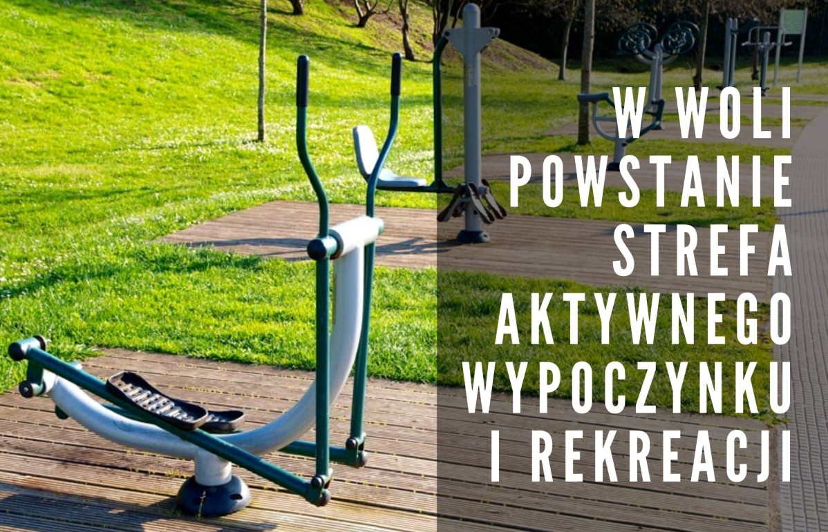 Grafika. Sprzęty siłowni zewnętrznej umiejscowione na drewnianym podłożu wśród drzew i zieleni w parku. Na grafice opis: W Woli powstanie strefa aktywnego wypoczynku i rekreacji.