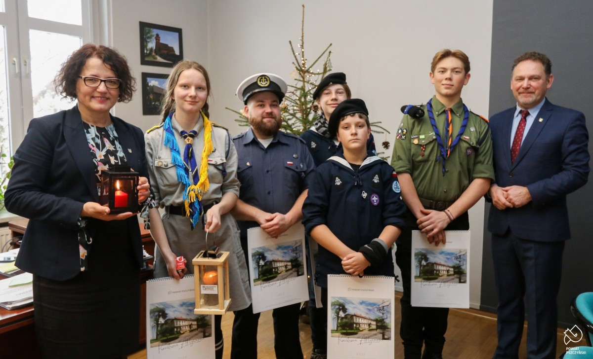 Harcerze z wicestarostą i starostą, która w dłoniach trzyma znicz z betlejemskim światłem pokoju.