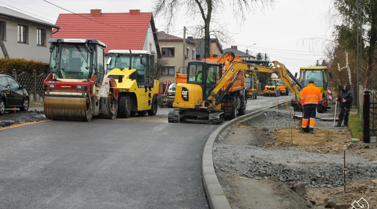 Roboty drogowe przy przebudowie ul. Jedności w Studzionce. Koparki i robotnicy.