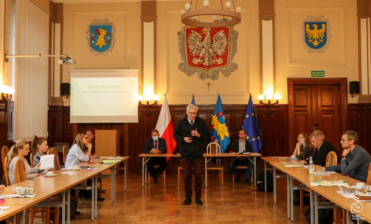 Sala sesyjna pszczyńskiego starostwa, stoły ustawione w podkowie, przed nimi prowadzący spotkanie.