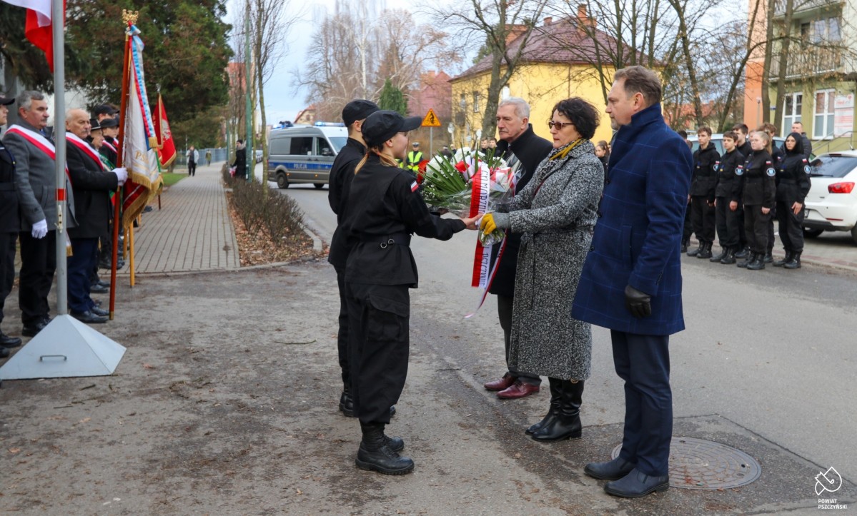 Włodarze powiatu pszczyńskiego składający kwiaty przy tablicy na ul. Bogedaina.