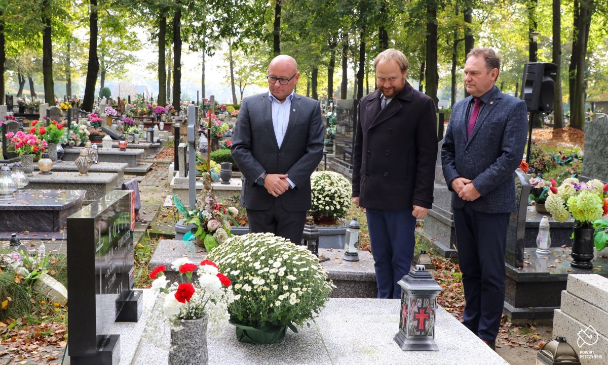 Samorządowcy i przedstawiciel IPN przy odznaczonym grobie.