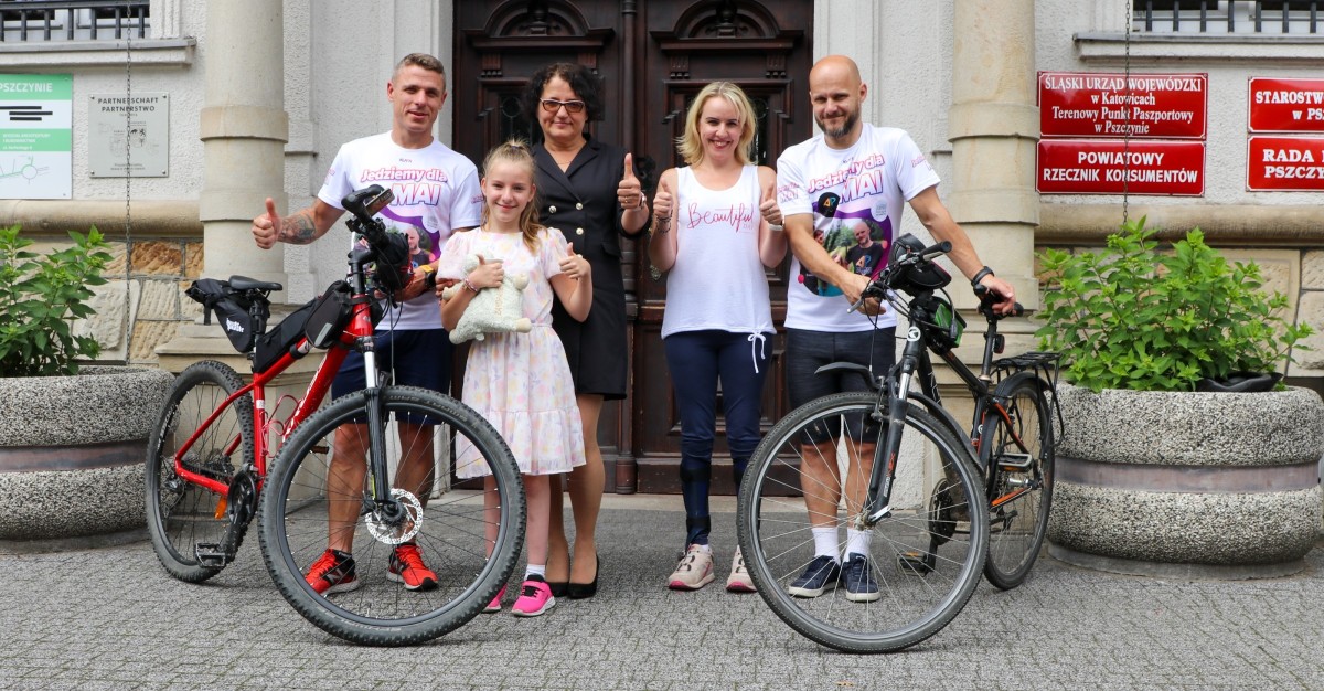 starosta, kolarze z rowerami, maja i jej mama przed budynkiem starostwa