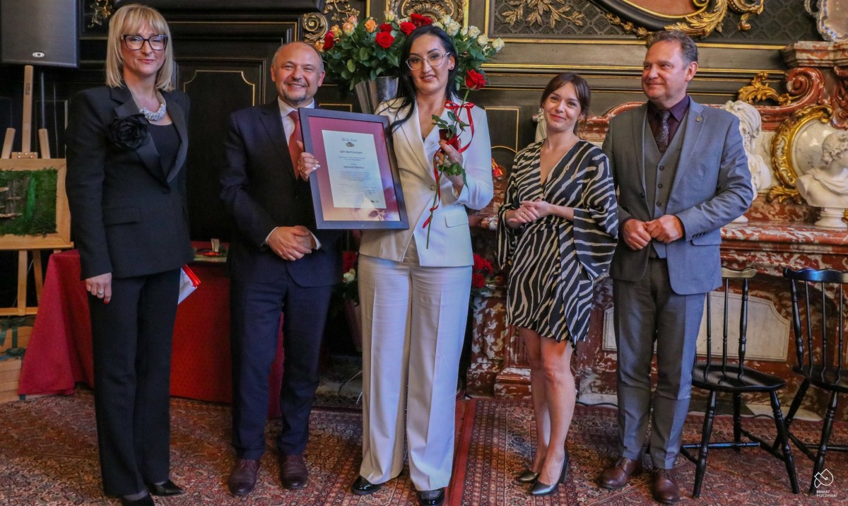 Agnieszka Rozmus ze starostą i innymi osobami wręczającymi odznaczenie