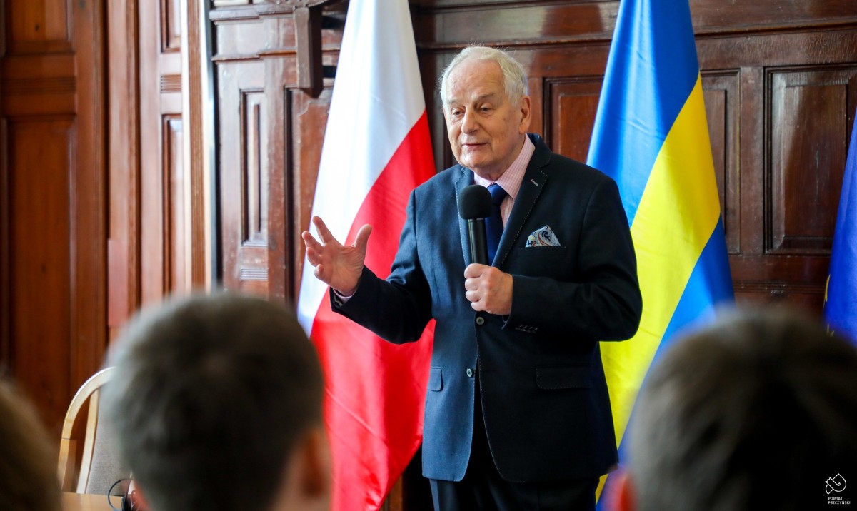 Naukowiec z mikrofonem w sali sesyjnej, opowiada.
