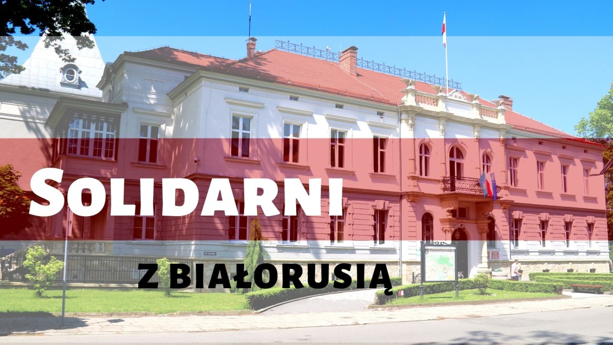 Grafika. Zdjęcie Starostwa Powiatowego w Pszczynie z nakładką biało-czerwono-białej flagi Białorusi. Tekst: solidarni z Białorusią.