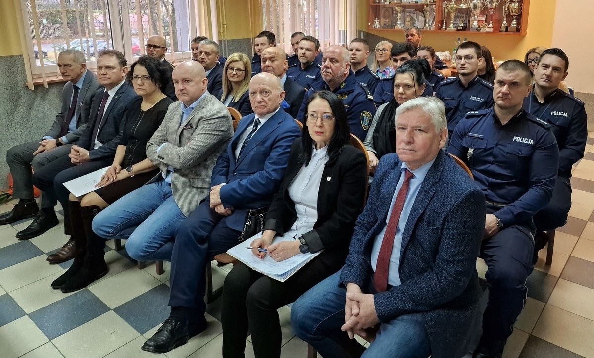 Trwa narada. Uczestnicy siedzący na krzesłach.