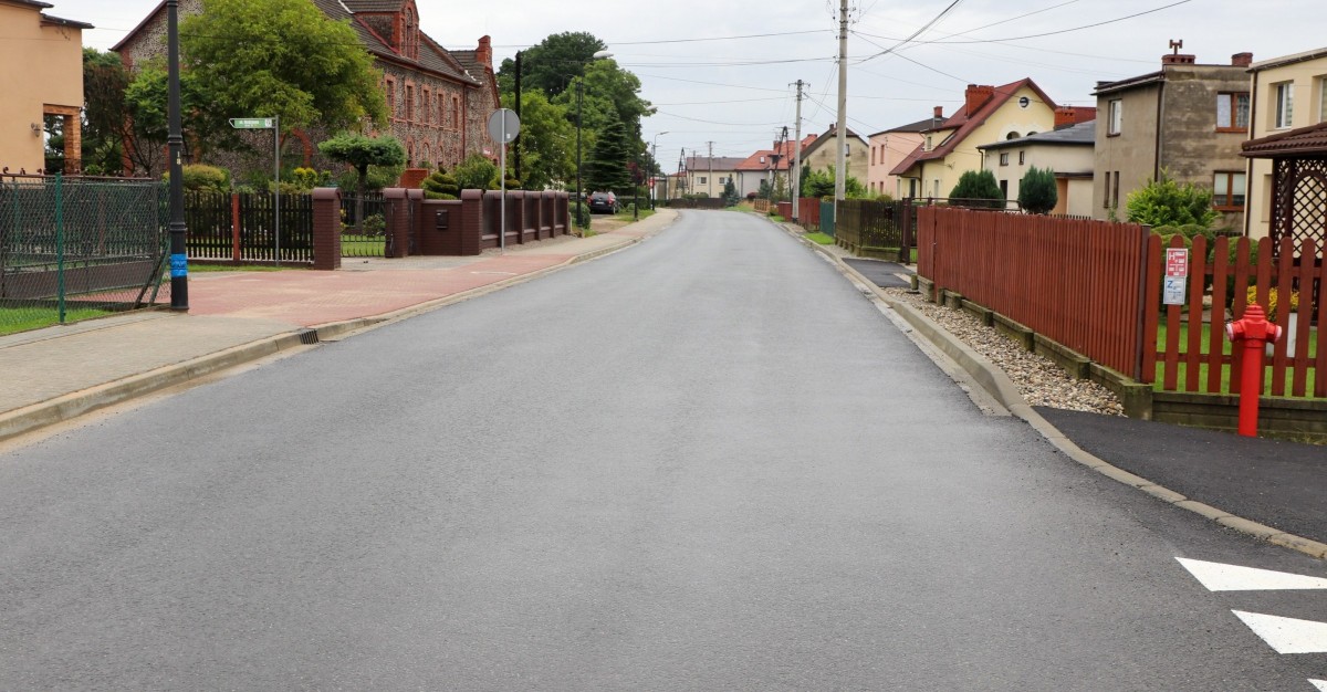 Ul. Rodzinna w Kobiórze po przebudowie, nowy chodnik i nawierzchnia drogi, wzdłuż której znajdują się posesje.