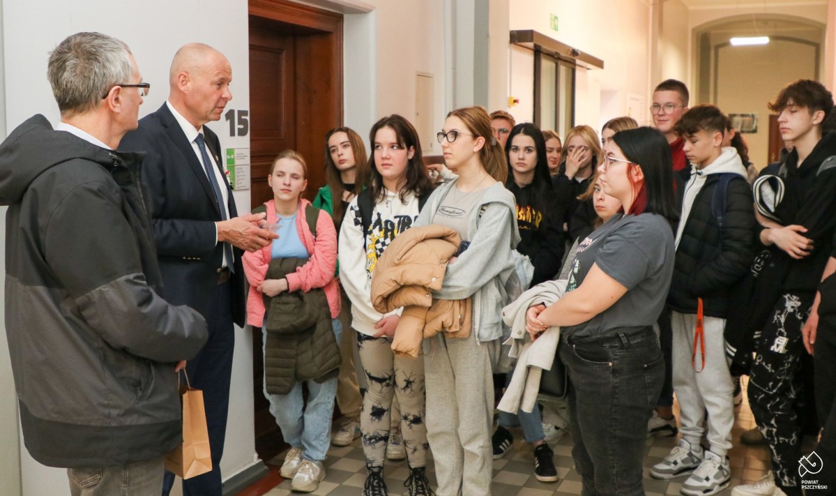 Sekretarz oprowadza młodzież po budynku starostwa.