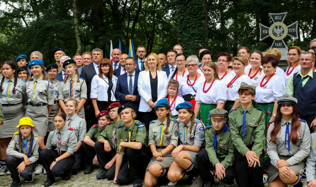 Uczestnicy we wspólnym zdjęciu przed mogiłą.